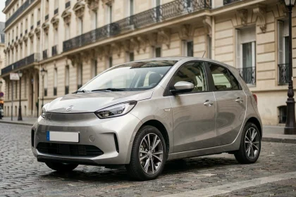 Citadine électrique moderne garée sur un pavé parisien avec façades haussmanniennes en arrière-plan